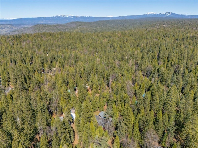 aerial view with a wooded view and a mountain view