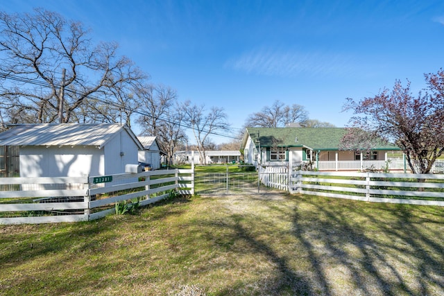 view of yard featuring a storage unit, a fenced front yard, and an outbuilding