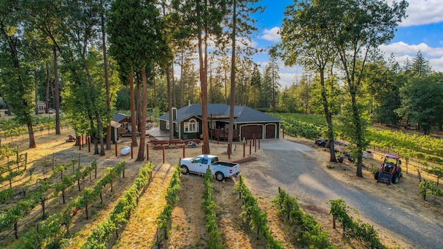 rustic home featuring dirt driveway, an outbuilding, fence, and a garage