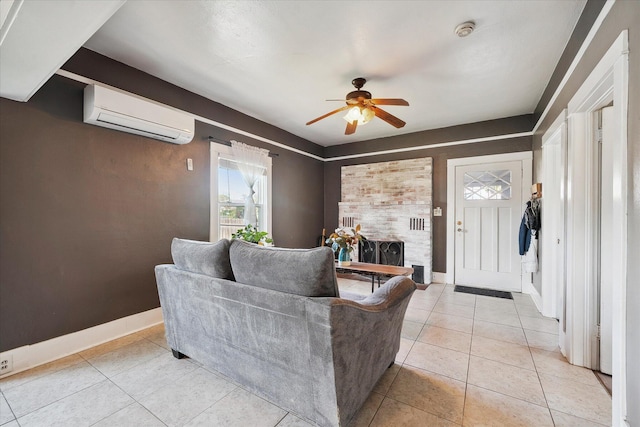 living area featuring a wall mounted air conditioner, ceiling fan, baseboards, and light tile patterned floors