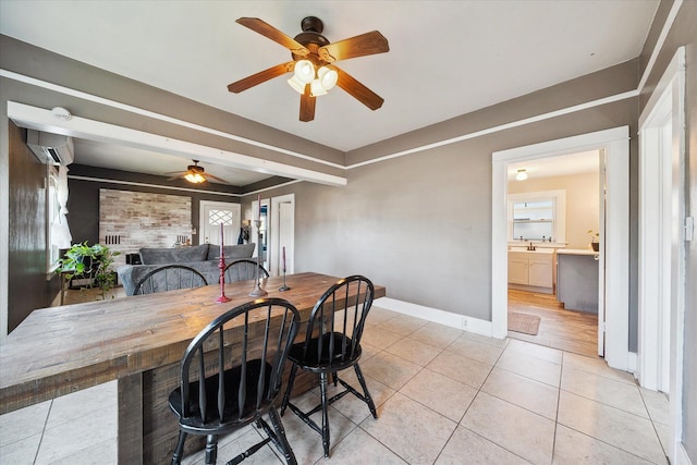 dining area with an AC wall unit, light tile patterned flooring, and baseboards