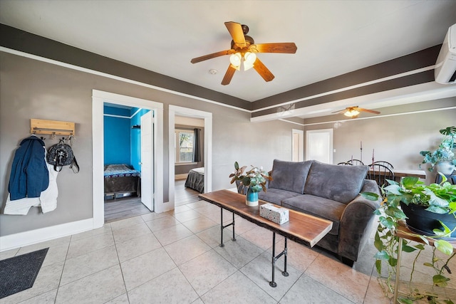 living room featuring baseboards, a ceiling fan, and light tile patterned flooring