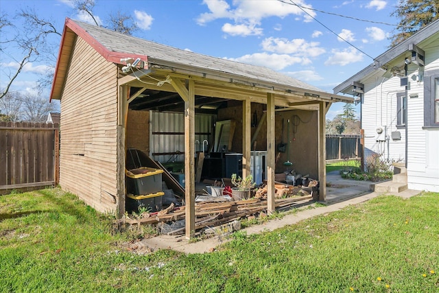 view of outbuilding featuring fence and an outbuilding