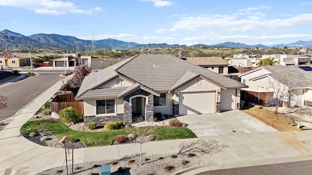 view of front of property featuring driveway, a tile roof, an attached garage, and fence