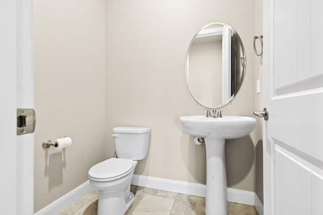 bathroom with toilet and baseboards