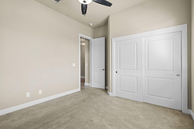 unfurnished bedroom with a closet, baseboards, carpet, and a ceiling fan