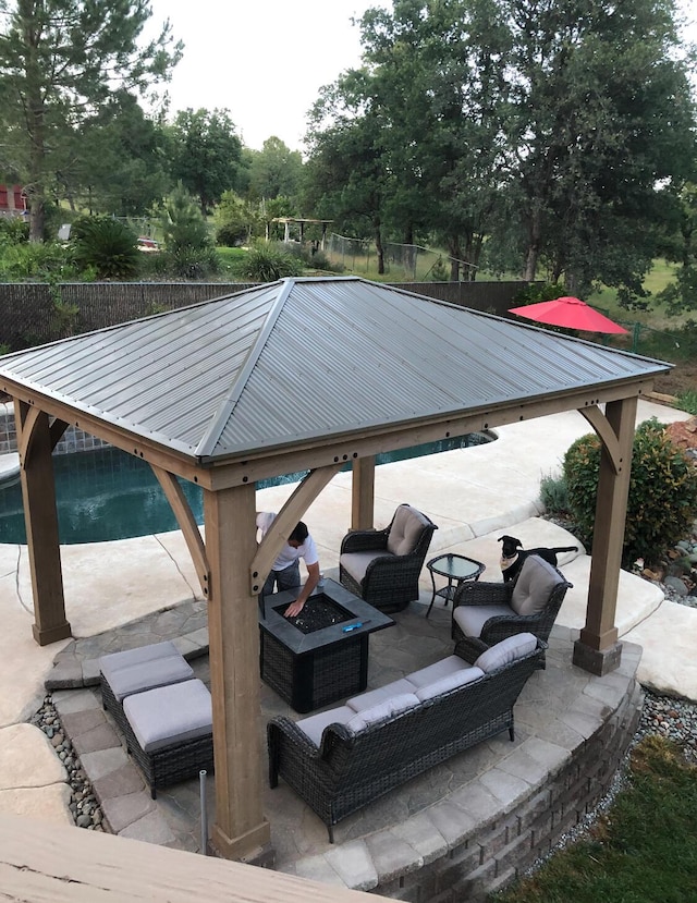 view of patio / terrace with a gazebo, a fire pit, and fence