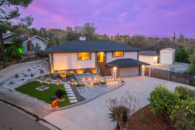 view of front of property featuring fence, an outdoor fire pit, a yard, stucco siding, and concrete driveway