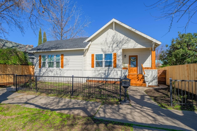 view of front facade with a fenced front yard and roof with shingles