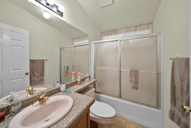 bathroom with toilet, combined bath / shower with glass door, tile patterned flooring, lofted ceiling, and vanity