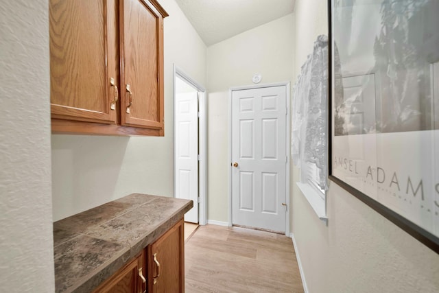 hallway with light wood finished floors and baseboards