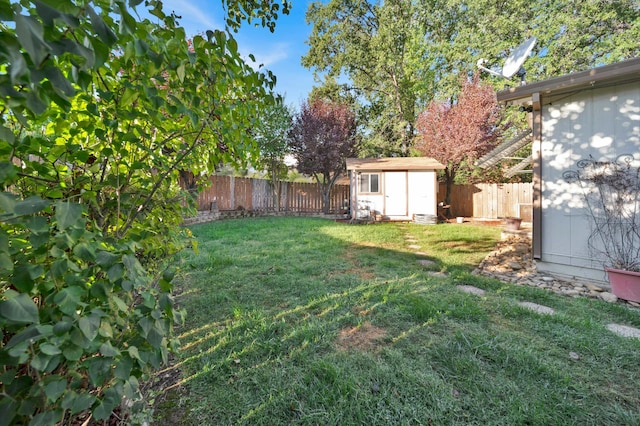 view of yard featuring an outbuilding, a fenced backyard, and a shed