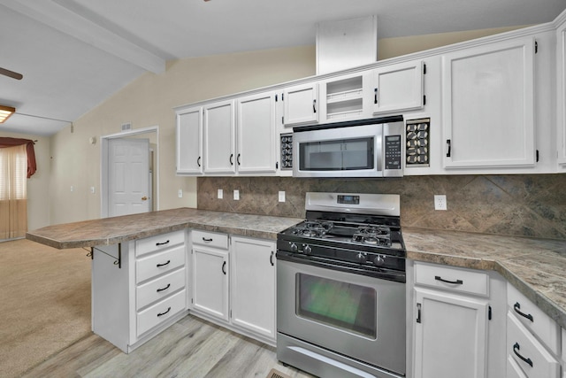 kitchen with a peninsula, light wood-style flooring, stainless steel appliances, decorative backsplash, and white cabinets