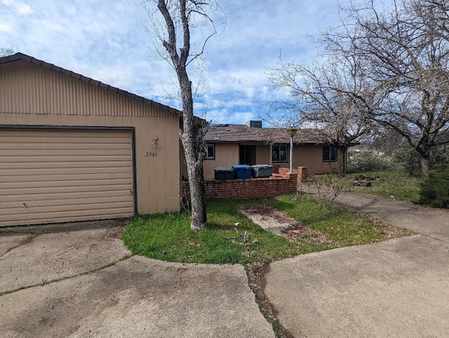 ranch-style home with a garage and concrete driveway