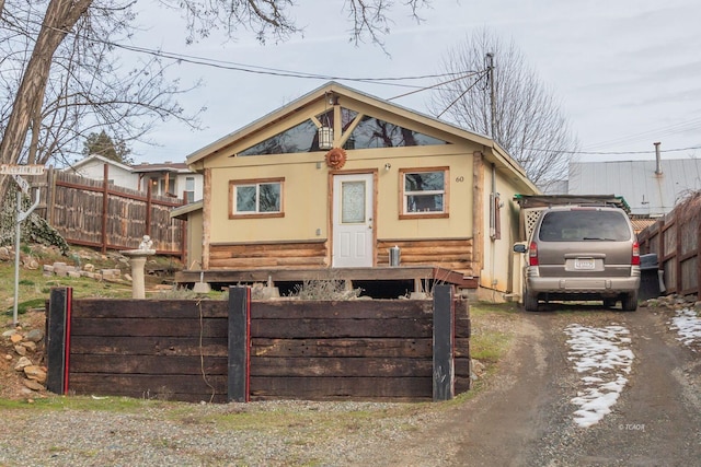 view of front facade featuring dirt driveway and fence