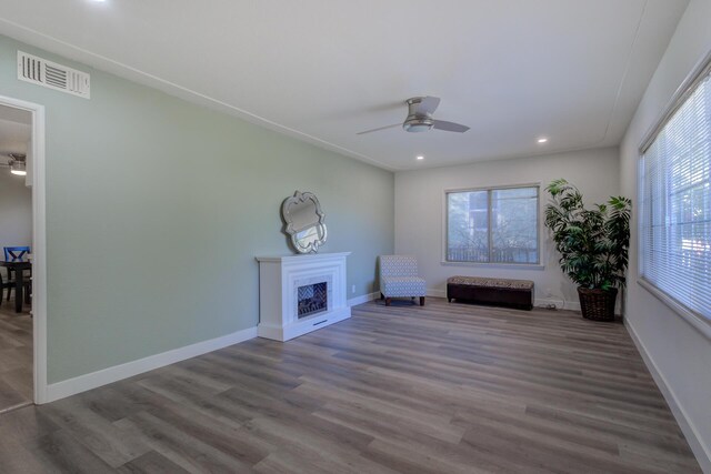 unfurnished room featuring wood finished floors, a fireplace, visible vents, and baseboards