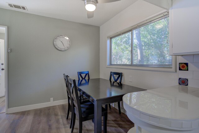 dining space with visible vents, ceiling fan, baseboards, and wood finished floors