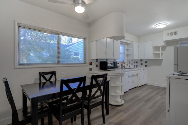 kitchen with visible vents, open shelves, freestanding refrigerator, stove, and a sink