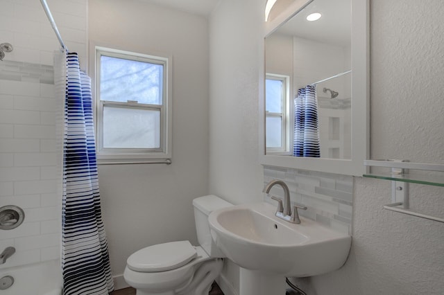 full bathroom featuring plenty of natural light, toilet, shower / tub combo, and tasteful backsplash