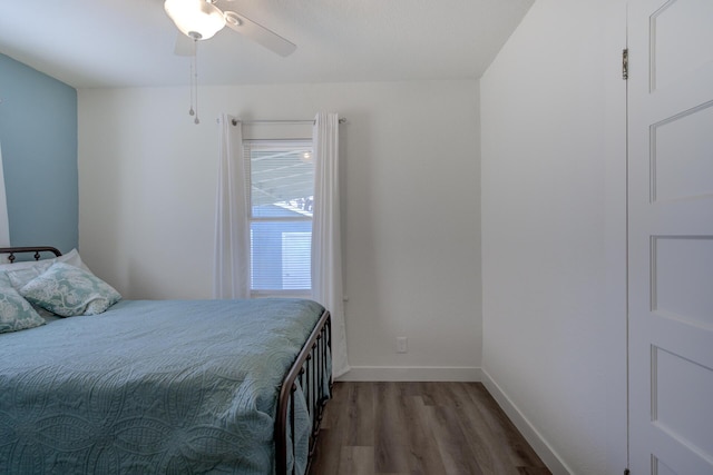 bedroom featuring wood finished floors, baseboards, and ceiling fan