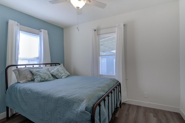 bedroom featuring ceiling fan, baseboards, and wood finished floors