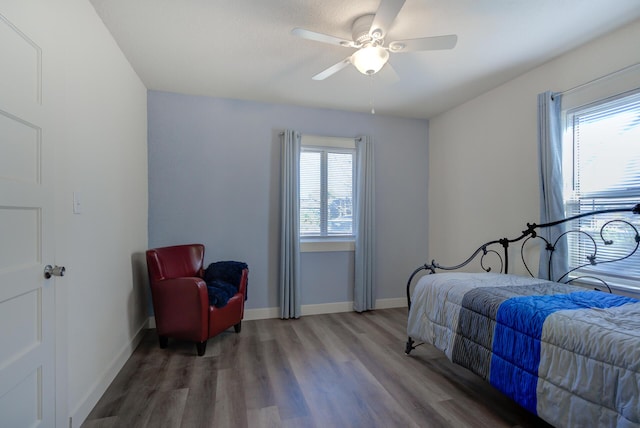 bedroom with ceiling fan, baseboards, and wood finished floors