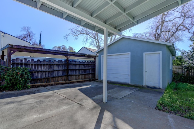 detached garage with fence and driveway