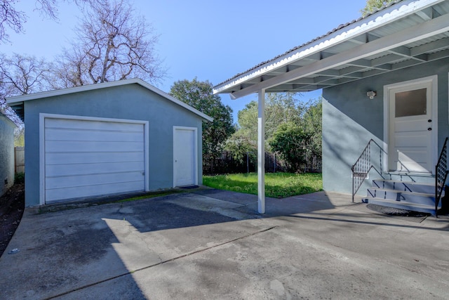 detached garage with driveway and fence