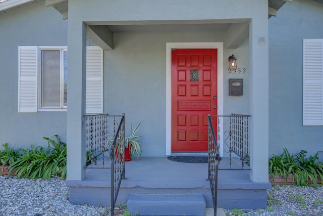 doorway to property featuring stucco siding