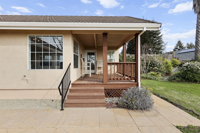 property entrance with stucco siding and a lawn