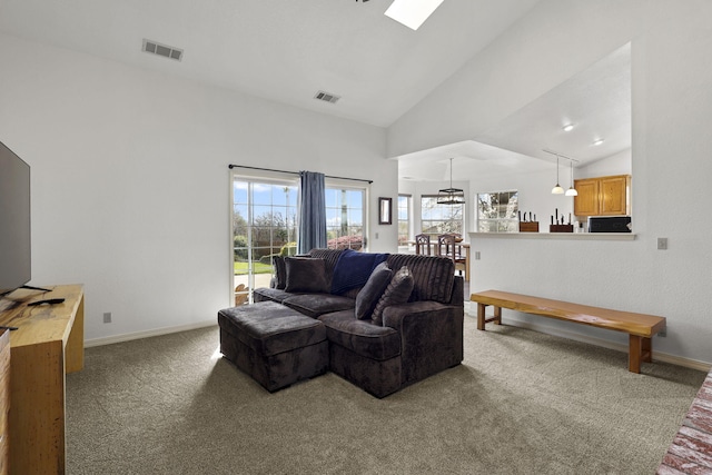 carpeted living room with visible vents, baseboards, and high vaulted ceiling