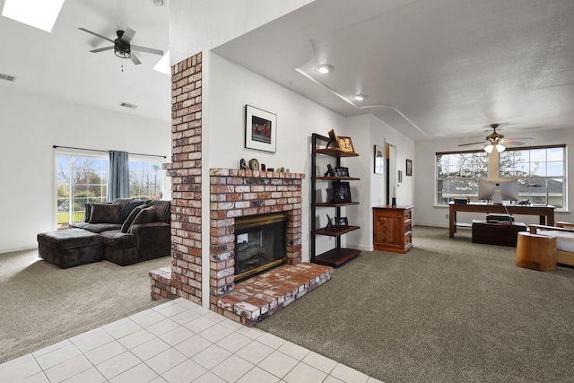 living area with plenty of natural light, a ceiling fan, and carpet floors