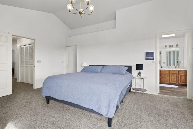 bedroom with baseboards, carpet floors, lofted ceiling, a chandelier, and connected bathroom