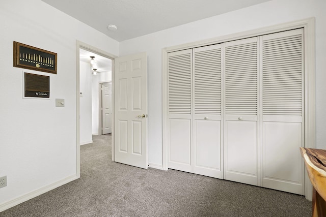 unfurnished bedroom featuring a closet, carpet floors, and baseboards