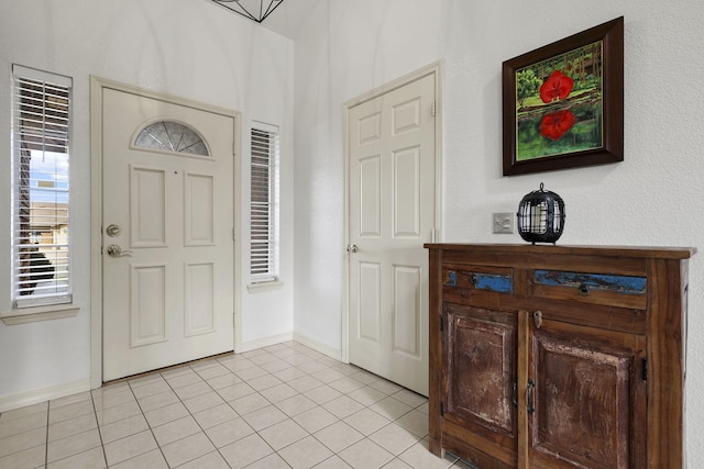 foyer with light tile patterned floors and baseboards