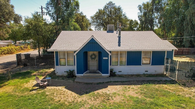 view of front of house featuring crawl space, a shingled roof, a front yard, and fence