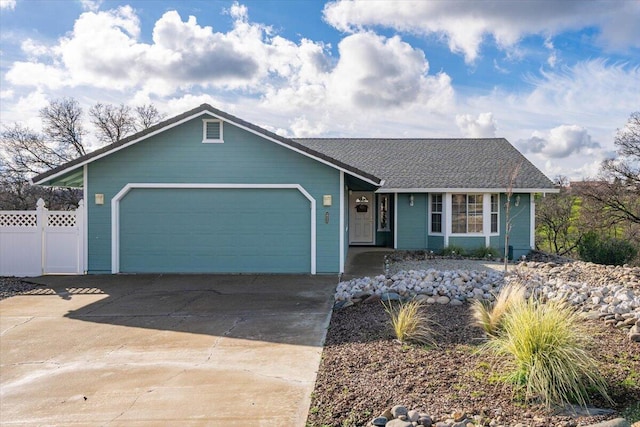 ranch-style home featuring concrete driveway, fence, and a garage