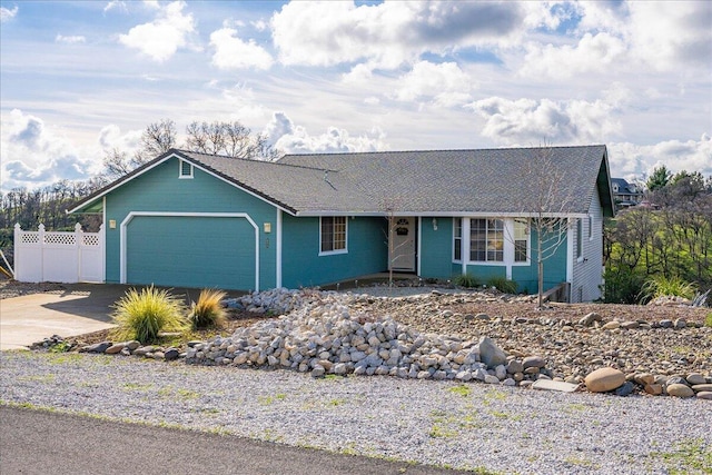 single story home with driveway, an attached garage, and fence