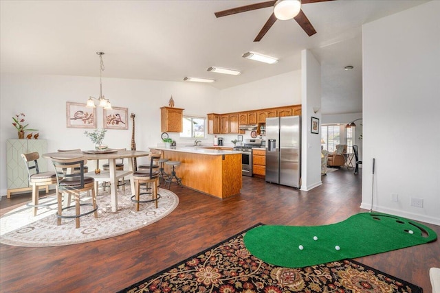 kitchen featuring brown cabinets, plenty of natural light, appliances with stainless steel finishes, and a peninsula