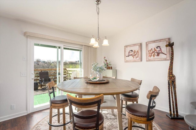 dining area with an inviting chandelier, dark wood-style floors, and baseboards