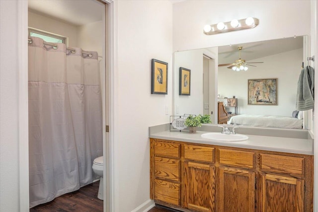 ensuite bathroom featuring toilet, ensuite bathroom, wood finished floors, ceiling fan, and vanity