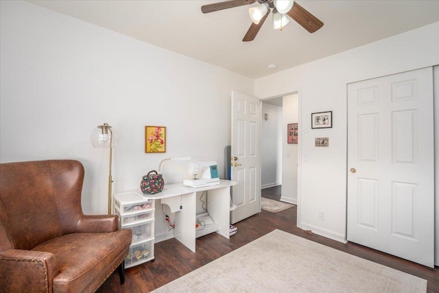 sitting room with dark wood-style floors, baseboards, and a ceiling fan