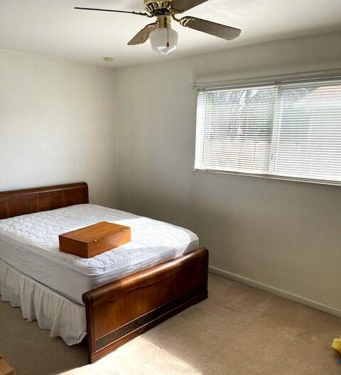 bedroom featuring a ceiling fan, carpet, and baseboards