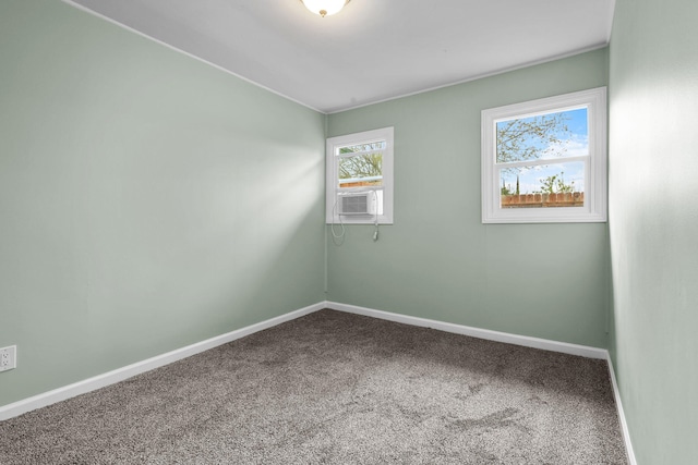 spare room with baseboards, cooling unit, and carpet floors