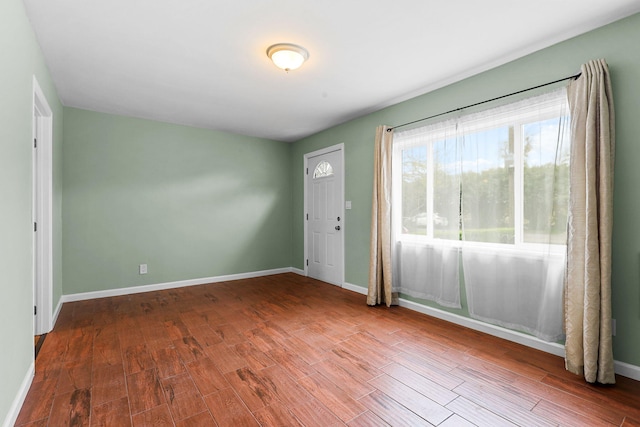 foyer featuring baseboards and wood finished floors