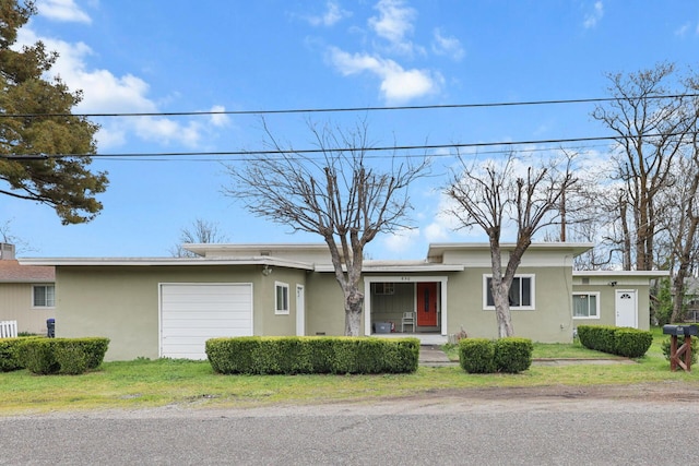 view of front facade with covered porch, stucco siding, and a garage