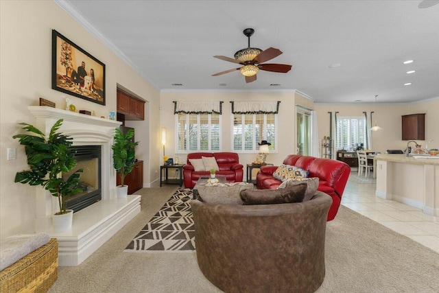 living area featuring a glass covered fireplace, recessed lighting, crown molding, light tile patterned floors, and baseboards