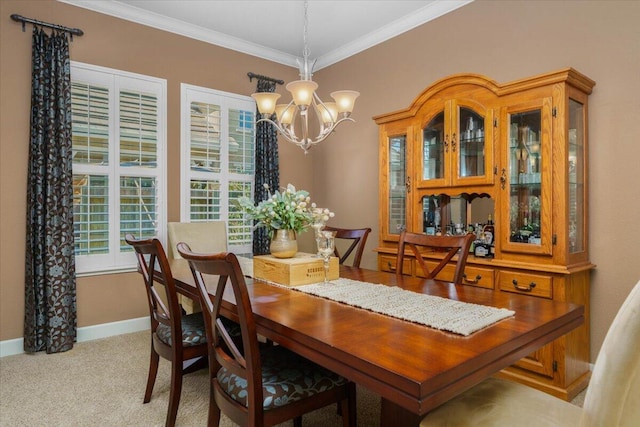 dining area with a notable chandelier, crown molding, baseboards, and carpet floors