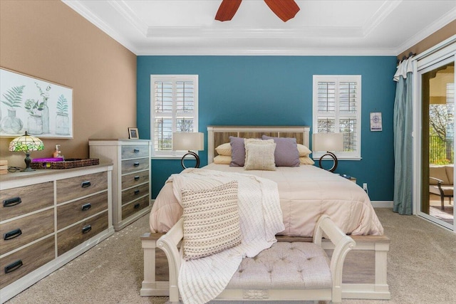 bedroom featuring a tray ceiling, light carpet, crown molding, and access to outside