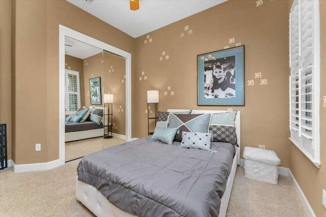 carpeted bedroom with a closet, ceiling fan, and baseboards